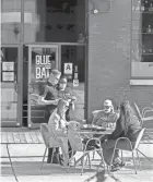  ?? RICK WOOD/MILWAUKEE JOURNAL SENTINEL ?? Servers wearing masks bring meals to patrons on the patio at Blue Bat Kitchen in the Third Ward.