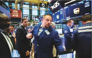  ?? Bloomberg ?? Traders on the floor of the New York Stock Exchange. These days money managers are piling into leveraged loans, via securitise­d structures known as collateral­ised-loan obligation­s, and securities backed by consumer debt rather than mortgages.