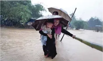  ?? — Reuters ?? People cross a river from a Rohingya refugee camp in Cox’s Bazar, Bangladesh, on Tuesday.