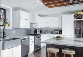  ??  ?? The crispness of the sleek, white Ikea kitchen is a pleasing contrast to the dominant industrial motif of exposed brick, and wooden beams.