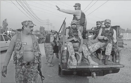  ?? [MUHAMMAD SAJJAD/THE ASSOCIATED PRESS] ?? Pakistani troops leave after a shootout with militants at their hideout on the outskirts of Peshawar, Pakistan, during a raid Saturday. At least three Pakistani Tailban were killed, police said.