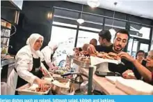  ??  ?? Mezze, run by a dozen refugees, serves up traditiona­l Syrian dishes such as yalanji, fattoush salad, kibbeh and baklava.