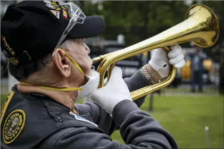  ?? JOHN MINCHILLO — THE ASSOCIATED PRESS ?? A bugler plays Taps as a motorcade of veterans stops outside the VA Medical Center for a wreath laying ceremony beside memorial stones on the premises, Monday, May 25, 2020, in the Brooklyn borough of New York.