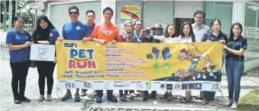  ??  ?? The organising committee with the promotiona­l banner on Miri Pet Run 2017.