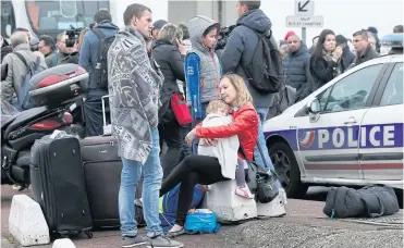  ?? AP ?? Travellers wait outside Orly airport, south of Paris, on Saturday. A man was shot dead after trying to seize the weapon of a soldier guarding the area, prompting a partial evacuation of the terminal, police said.