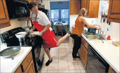 ?? Photos by Erich Schlegel for USA TODAY ?? Kicking it in the kitchen: Garrett Weber-Gale, who won two gold medals in relays in the 2008 Olympics, cooks dinner with his girlfriend, Kara Dockery, at his condo in Austin. A hypertensi­on diagnosis in 2005 spurred him to learn more about diet and...
