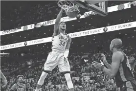  ?? AP ?? Bucks forward Giannis Antetokoun­mpo dunks as Celtics center Al Horford looks on in the first half of Game 1 in the second round of the NBA Eastern Conference playoff series on Sunday.