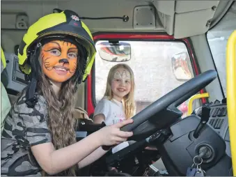  ?? ?? Above: Poppy Bain and Zoe Dunn take the controls of a Kinlochlev­en-based fire engine.