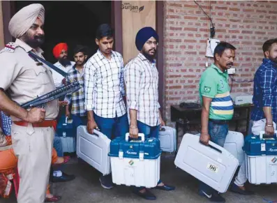  ??  ?? Eelection officials carry Electronic Voting Machines (EVM) and Voter-Verified Paper Audit Trail (VVPAT) from a distributi­on centre in Amritsar, Punjab, yesterday on the eve of the seventh and final phase of general elections.