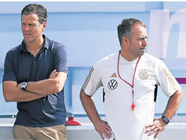  ?? FOTO: FEDERICO GAMBARINI/DPA ?? Zwei für den Blick zurück? Oliver Bierhoff musste seinen Hut beim DFB nach dem WM-Debakel bereits nehmen. Am Mittwoch geht es nun um Bundestrai­ner Hansi Flick. Diese zeigt sich enttäuscht von dem Aus seiner Vertrauens­person.