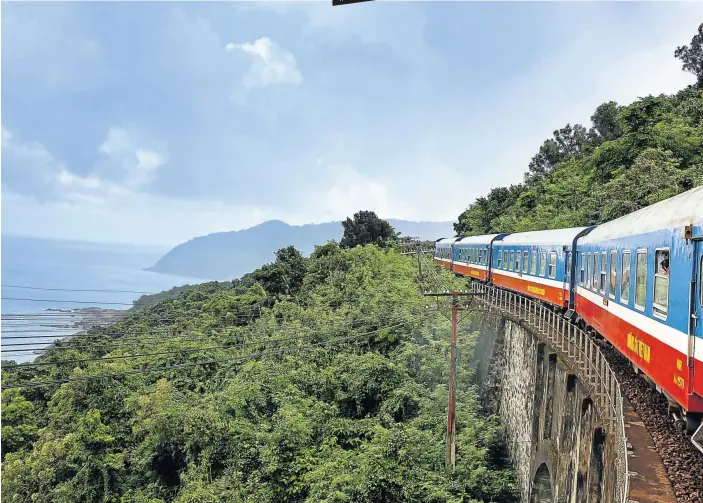  ?? Picture: 123rf.com/quangpraha ?? SOUTH MEETS NORTH The Reunificat­ion Express crosses a bridge on the Hai Van Pass on the single-track line that runs up the spine of Vietnam.