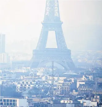  ?? REUTERS ?? The Eiffel Tower is surrounded by a small-particle haze which hangs above the skyline in Paris in 2016 as the City of Light experience­d the worst air pollution in a decade.