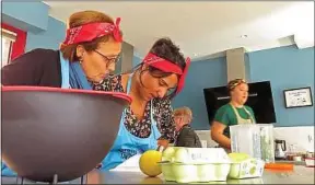  ??  ?? Hadjila et Somia planchent sur la recette du dessert du restaurant solidaire.