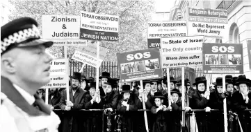  ??  ?? People wave placards as they protest against the visit by Netanyahu in London, Britain. — Reuters photo