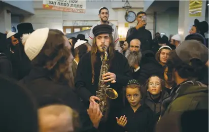  ?? (David Saveliev/JTA) ?? A HASSIDIC MAN plays klezmer on saxophone at a gathering in Uman last week.