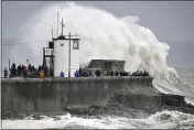  ?? BEN BIRCHALL — PA VIA AP ?? People watch waves and rough seas pound against the harbour wall at Porthcawl in Wales, as Storm Dennis sweeps across the country, Saturday.