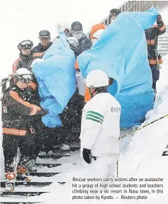  ??  ?? Rescue workers carry victims after an avalanche hit a group of high school students and teachers climbing near a ski resort in Nasu town, in this photo taken by Kyodo. — Reuters photo