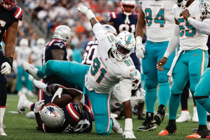  ?? WINSLOW TOWNSON / ASSOCIATED PRESS FILE (2021) ?? Miami Dolphins defensive end Emmanuel Ogbah (91) reacts after tackling New England Patriots running back James White during a 17-16 win Sept. 12, 2021, in Foxborough, Mass.