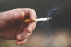  ?? JEFF CHIU/AP while smoking on Dec. 2, ?? A MAN HOLDS A LIT CIGARETTE 2020, in San Francisco.