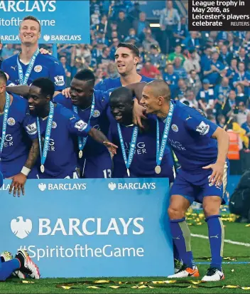  ?? REUTERS ?? Glory be: Vichai holds the Premier League trophy in May 2016, as Leicester’s players celebrate