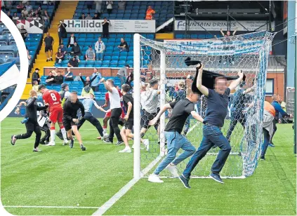  ??  ?? Rangers fans run amok at Rugby Park, which led to the roof of the disabled enclosure being destroyed