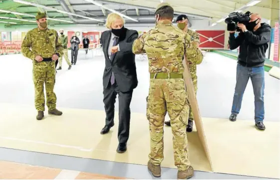  ?? Foto: Jeff Mitchell ?? Boris Johnson se reúne con las tropas que instalan un centro de vacunación en el distrito Castlemilk, en Glasgow, Escocia.
