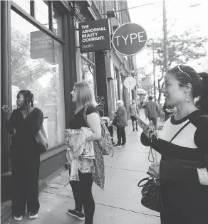  ?? NATHAN DENETTE / THE CANADIAN PRESS ?? People react as they look outside the beauty supply store owned by Deciem in Toronto on Tuesday. The company has closed all locations unexpected­ly.