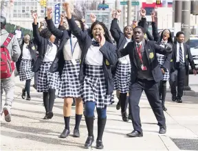  ?? AP ?? Multicultu­ral Academy Charter School student Kayla Brooks (centre) walks along with other students towards the school district’s building as they participat­e in a walkout to protest gun violence yesterday.