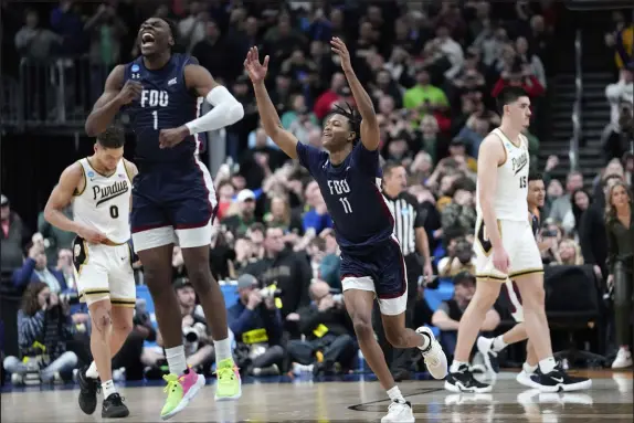  ?? Paul Sancya
The Associated Press ?? Fairleigh Dickinson’s Joe Munden Jr. (1) and Sean Moore exult Friday night after stunning No. 1 seed Purdue 63-58 in Columbus, Ohio.