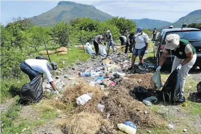  ?? Picture: ANDISA BONANI ?? KEEP IT CLEAN, KEEP IT GREEN: Community members assisted EMLM and the department of environmen­tal affairs and tourism in their clean-up campaign by picking up illegally dumped litter along the road to Ezibeleni