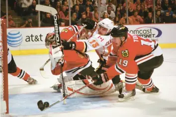  ?? CHICAGO TRIBUNE ARCHIVE ?? Nikolai Khabibulin, left, makes a save on Calgary’s Michael Cammalleri (13) while Jonathan Toews clears the puck during the 2009 Stanley Cup Playoffs.