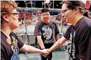  ??  ?? Shawnee High School team members Zach Nunnally, left, Nathaniel Bunner and Jacob Dennis join hands before their competitio­n. See more photos online at oklahoman.com.