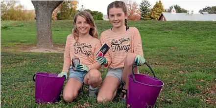  ?? HELEN NICKISSON/STUFF ?? Lily (left) and Anna have taken to using buckets for their rubbish-collecting walks, after the bags they were using broke.