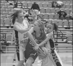  ?? Photo by Gerren Smith ?? AGGRESSIVE DEFENSE: Magnet Cove’s Baylie Martin (20) and Taysia Buckley (1) double-team defensivel­y against Glen Rose’s Aubrey Pennington (00) during seventh grade girls hoops action.