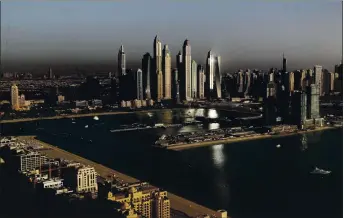  ?? AMRAN JEBREILI — THE ASSOCIATED PRESS ?? Luxury towers dominate the skyline in the Marina district, center, and the new Dubai Harbour developmen­t, right, as seen from the View at the Palm Jumeirah observatio­n deck in Dubai, United Arab Emirates.