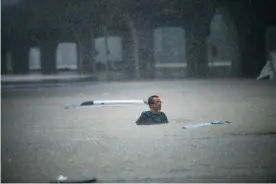  ??  ?? People swim in floodwater in Zhengzhou. Photograph: Rex/Shuttersto­ck