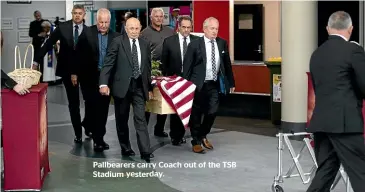  ??  ?? Pallbearer­s carry Coach out of the TSB Stadium yesterday.