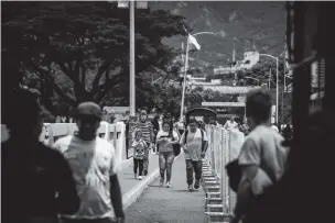  ?? NATHALIA ANGARITA/NEW YORK TIMES FILE PHOTO ?? People cross the Simón Bolívar Internatio­nal Bridge last year in Cúcuta, Colombia, on the country’s border with Venezuela. Colombia, with U.S. help, is providing temporary visas to Venezuelan migrants; still, financial struggles are leading many to leave for the United States.