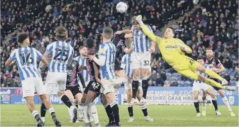  ?? ?? Huddersfie­ld goalkeeper Lee Nicholls makes a flying punched clearance in the game against Posh. Photo: Joe Dent/theposh.com.