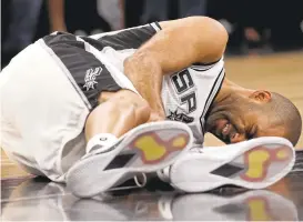  ?? JERRY LARA/THE SAN ANTONIO EXPRESS ?? San Antonio floor leader Tony Parker holds his left leg after getting injured in Game 2.