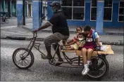  ?? RAMON ESPINOSA — THE ASSOCIATED PRESS ?? A man transports children on his tricycle in Havana, Cuba.