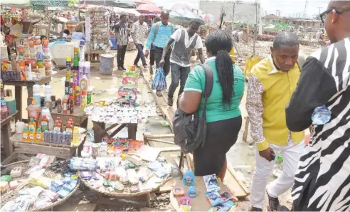  ?? Photo: Benedict Uwalaka ?? People use a makeshift bridge at Agege in Lagos