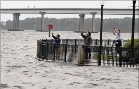  ??  ?? „ Students use anemometer­s to measure wind speeds at Union Point Park in New Bern, North Carolina, as the storm swept in, while a park, above right, was submerged.