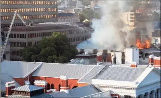  ?? Jerome Delay / Associated Press ?? Firefighte­rs spray water on flames erupting from a building at South Africa's Parliament in Cape Town on Sunday.