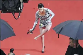  ?? AFP/GETTY IMAGES ?? Jury member Kristen Stewart takes off her heels at the première of BlacKkKlan­sman at Cannes. “Things have to change immediatel­y,” she says of the festival’s wardrobe guidelines.