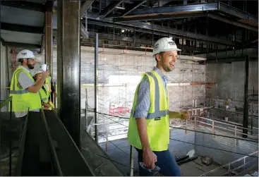  ?? NWA Democrat-Gazette/DAVID GOTTSCHALK ?? Martin Miller (right), executive director of TheatreSqu­ared, describes the West Theatre on Monday inside the new TheatreSqu­ared building in Fayettevil­le. City officials and guests toured the building that is under constructi­on to see the progress of the facility that will house two theaters and other amenities.