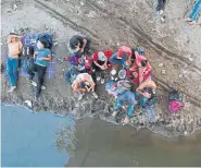  ??  ?? Honduran migrants traveling ina caravan rest on the banks of the Suchiate River, the natural border between Tecun Uman, Guatemala, and Ciudad Hidalgo, Mexico, on Sunday.