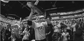  ?? CHRISTOPHE­R HANEWINCKE­L/USA TODAY SPORTS ?? Predators fan Brian Martin throws a catfish on the ice before Game 2.