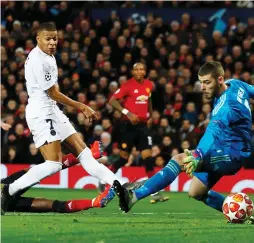  ?? (Reuters) ?? PARIS SAINT-GERMAIN’S Kylian Mbappe scores his side’s second goal past Manchester United ’keeper David de Gea in the 60th minute of PSG’s 2-0 away victory over the Red Devils on Tuesday night in their Champions League last-16 first leg.