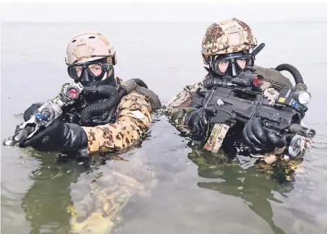  ?? FOTO: DPA ?? Kampfschwi­mmer des Kommando Spezialkrä­fte der Marine gehen bei einer Übung aus der Ostsee an Land.
